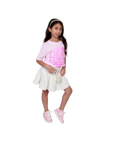 Pre-teen girl model wearing Barbie branded Malibu palm logo t-shirt with white pleated skirt and pink and white faux leather lace up sneakers with faux pearl over-the-shoulder coin purse.