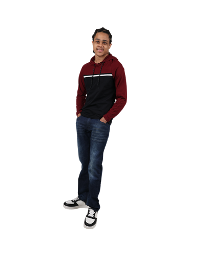 Young man wearing a burgundy, white and black color block knit hoodie with saddle stitch jeans and black and white designer inspired sneakers.