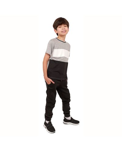 The boy model wears the "Distortion" Short Sleeve Color Block Tee, "True Indigo" Fleece Jogger Pants, and "Air" Elastic Lace Sneakers.