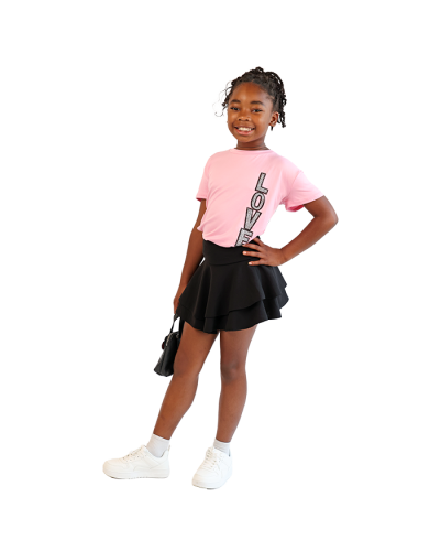 The girl model wears the "Davida" Short Sleeve Blush Love Vertical Side Patch Tee, black "Chocolate" Wave Skirt, and the white "Forever" Solid Color Pleather Athletic Shoes.