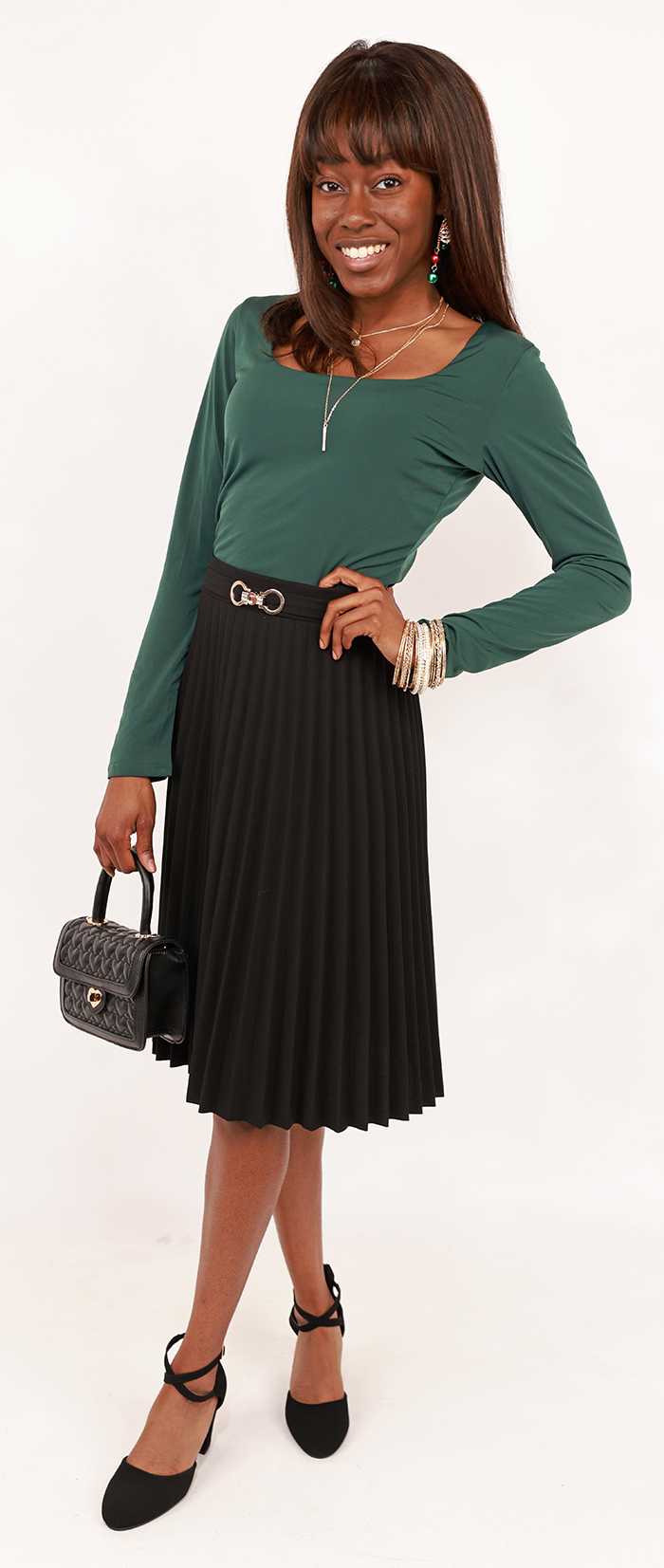 The female contemporary model wears the kelly green "New Mode" 3/4" Long Sleeve Square Neck Top, black "Mango" 23" Gold Embellished Skirt, and black "Top Guy" 3" Thick Closed Toe Ankle Strap Pumps. 