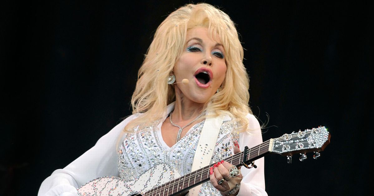 Pictured is Dolly Parton is a rhinestone western inspired look performing