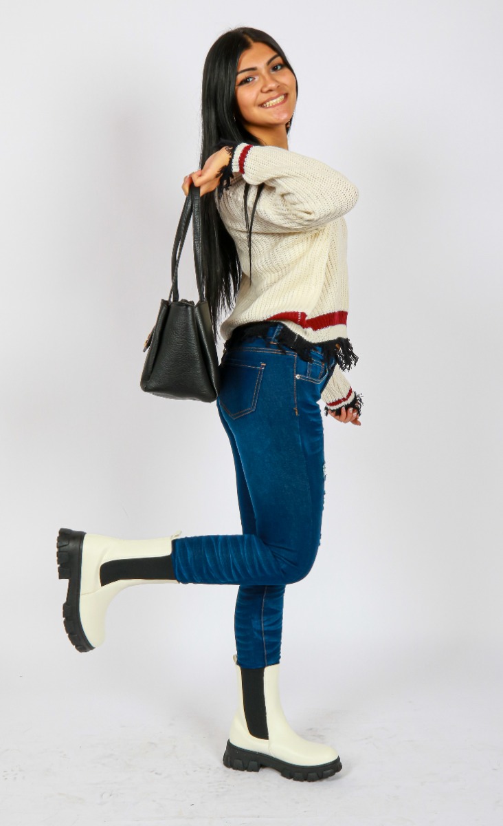Sydney's look for My Melrose features the "No Comment" Long Sleeve V-Neck Striped Tatter Knit Sweater over the "BR" Med 10" Dark Wash Distressed Cuffed Denim Skinny Jeans tucked into the white "Wild" Lug Pleather Elastic 6 1/2" Booties