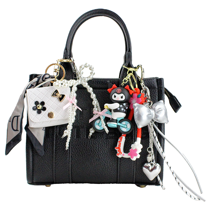 The "Tops" 'The Tote Bag' Small Crossbody Satchel is pictured with a variety of bag charms.